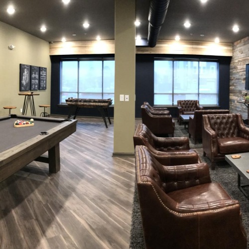 a game room with pool table and chairs