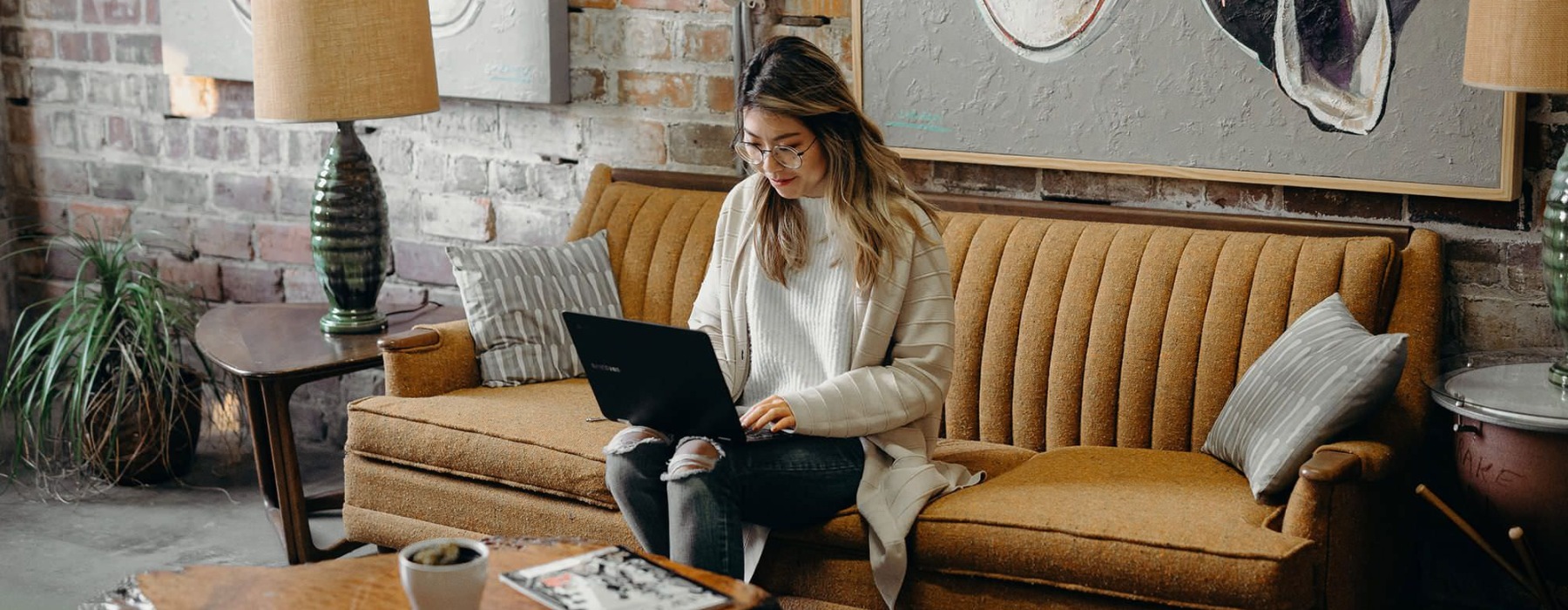 woman sitting on a couch working on a computer