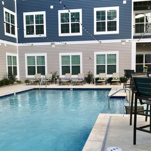 a pool with chairs and tables by it